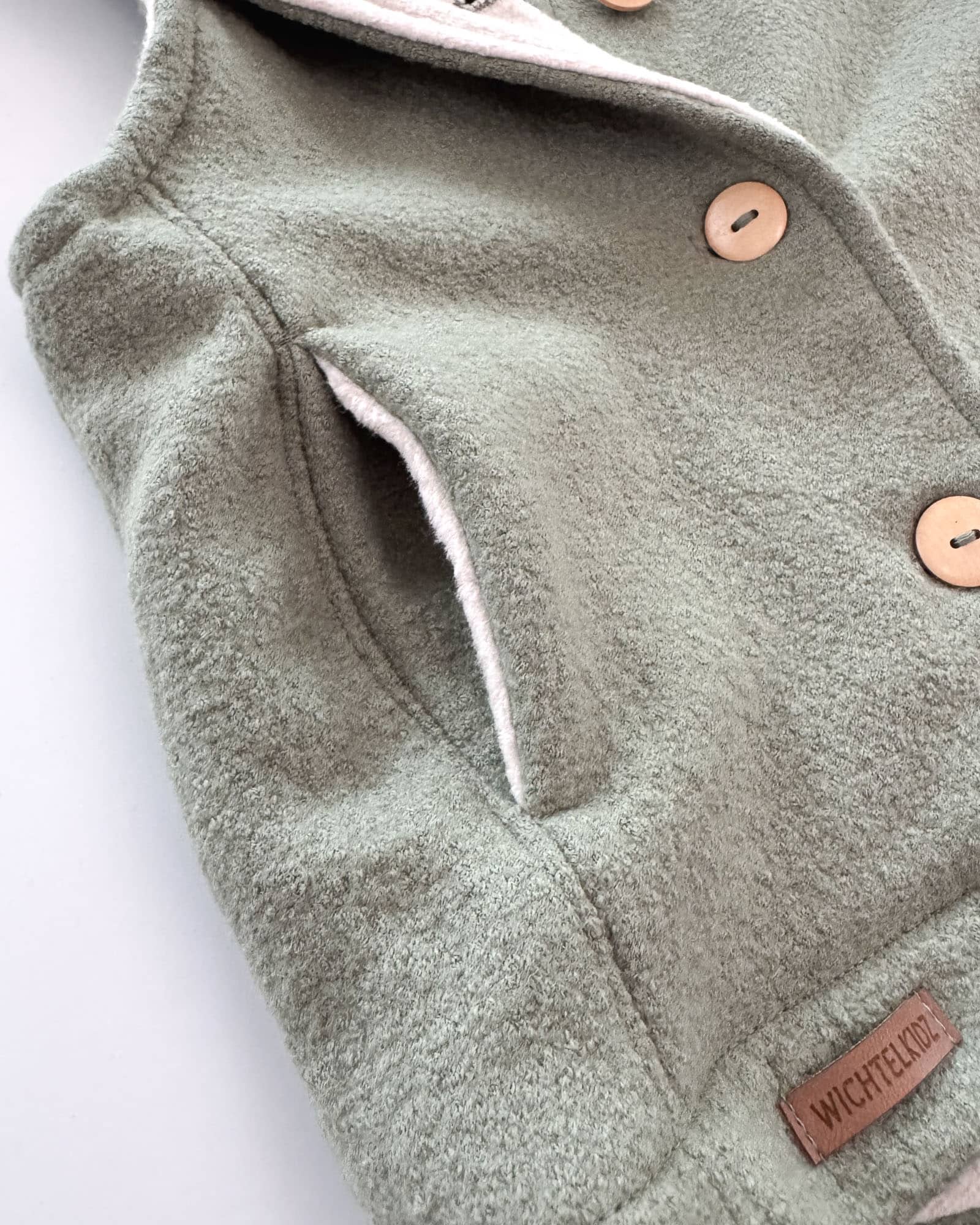 Sofortkauf: Merino-Walkweste mit Holzknöpfen in Salbei/Baumwollfleece Creme, Gr. 98/104 – Bild 3